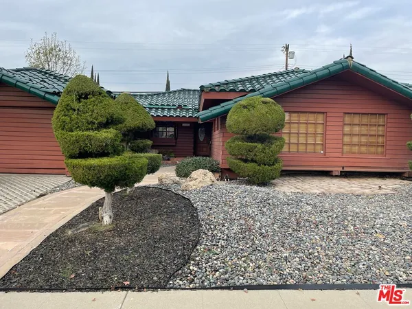 a front view of a house with a yard and potted plants