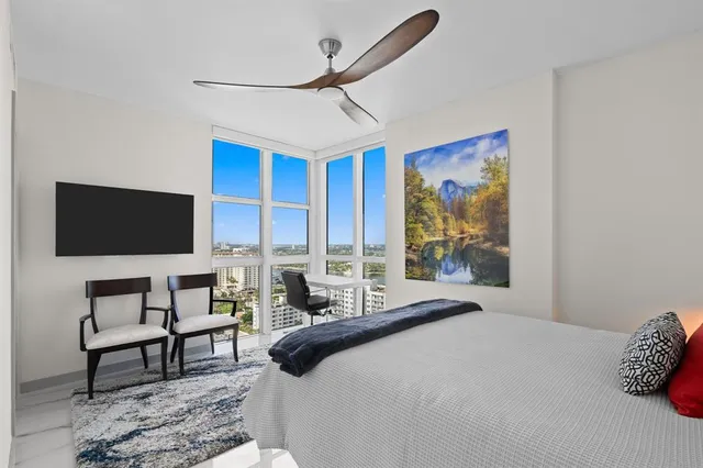 a bedroom with a bed a couch and a flat screen tv