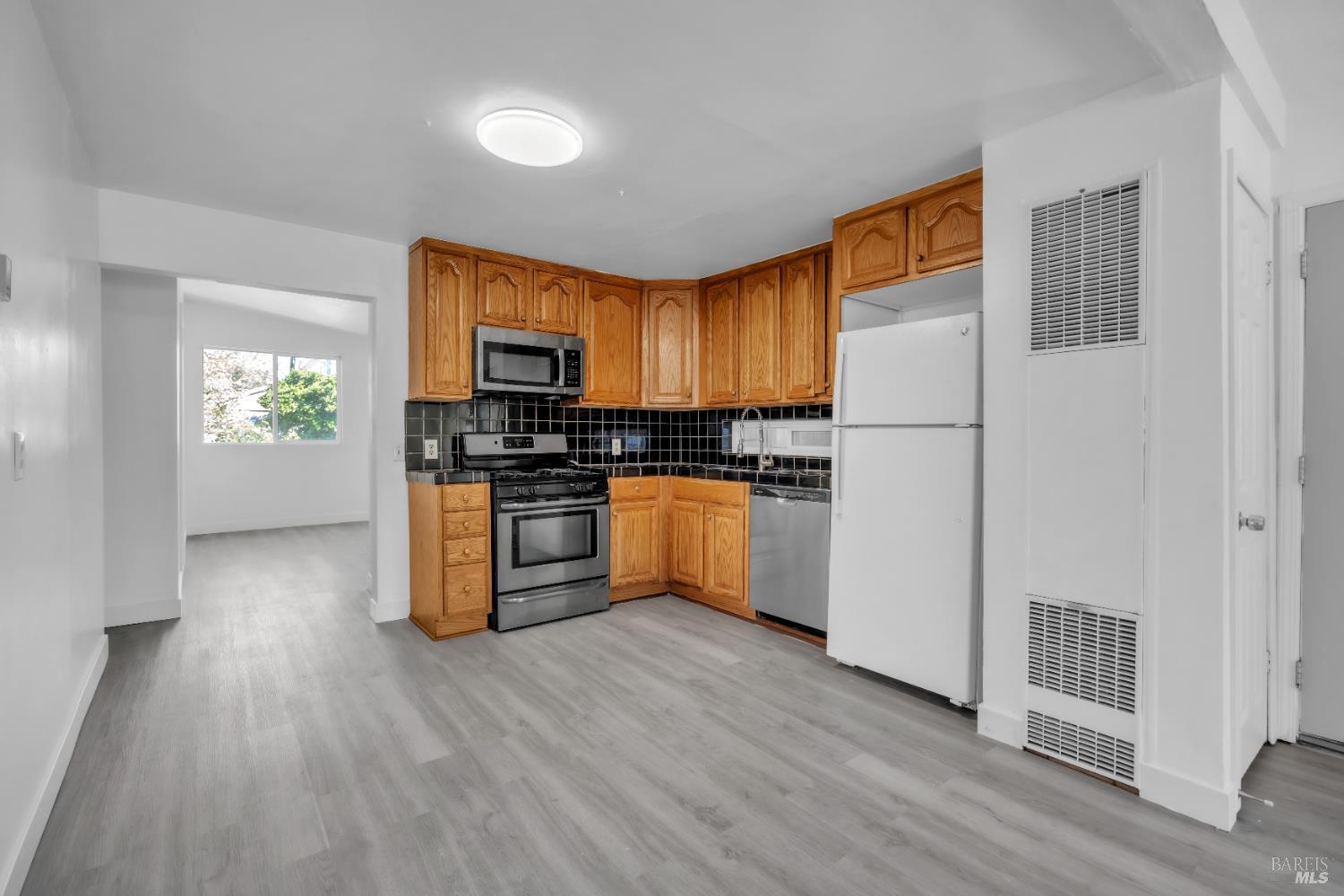 514 Montezuma Street Rio Vista, CA 94571 - Photo 12 of 36 a kitchen with granite countertop a stove a sink and a refrigerator