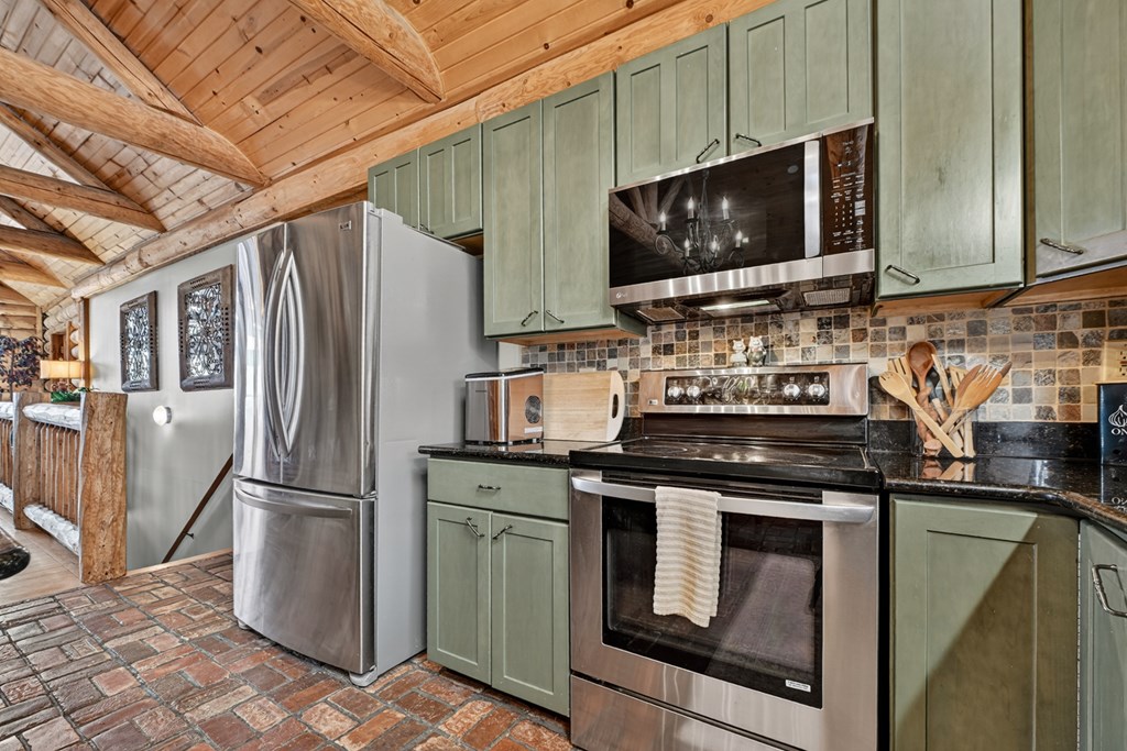 260 Observation Lane Blue Ridge, GA 30513 - Photo 34 of 100 a kitchen with stainless steel appliances granite countertop a stove microwave and refrigerator