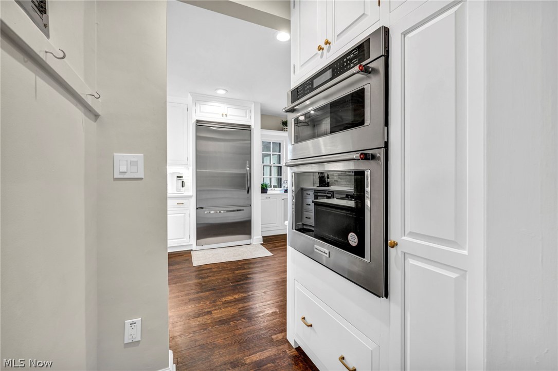 17409 Fernway Road Cleveland, OH 44120 - Photo 21 of 47 Kitchen featuring white cabinets, dark hardwood / wood-style flooring, and appliances with stainless steel finishes