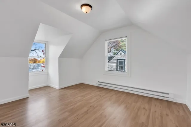 an empty room with a window and wooden floor