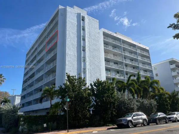 a view of a buildings and car parked on road