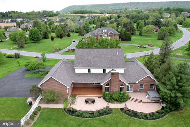 a dining room with wooden floor a chandelier a wooden table and chairs