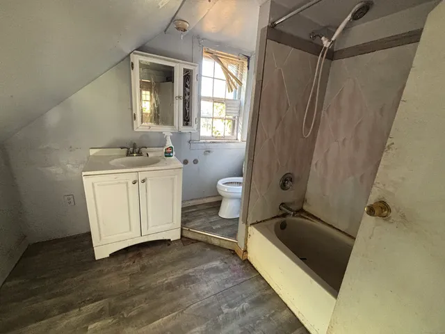 a spacious bathroom with a granite countertop sink toilet and shower