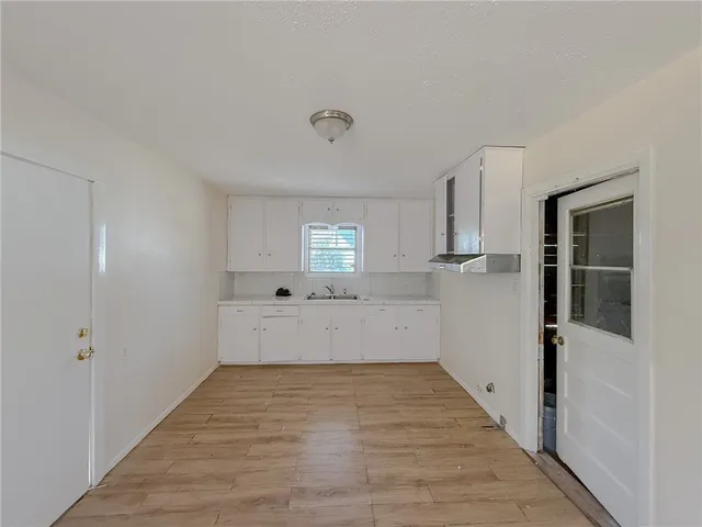 a view of a kitchen with wooden floor and electronic appliances