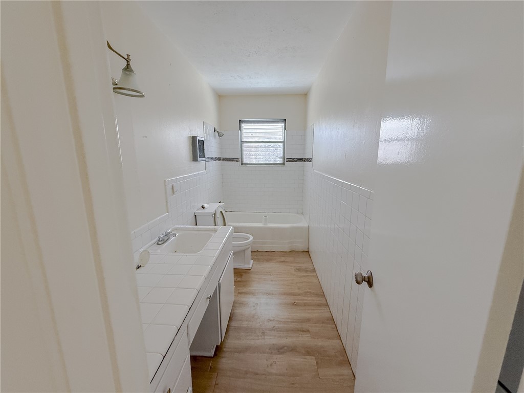 833 Booty Street Sinton, TX 78387 - Photo 6 of 9 a bathroom with a sink a mirror and a bathtub