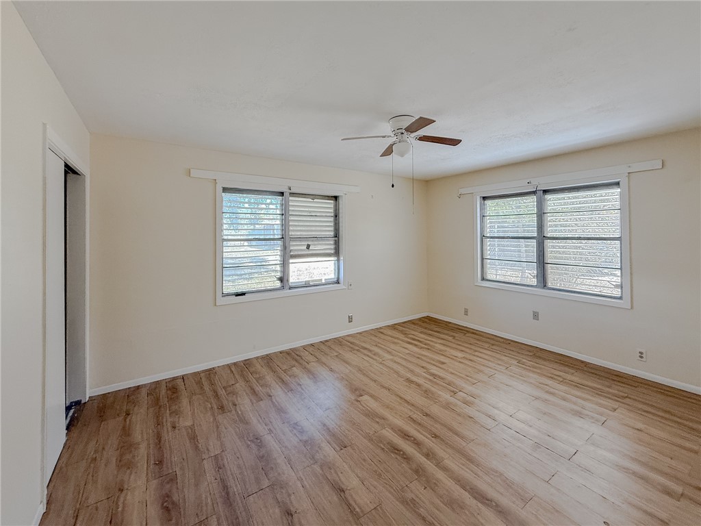 833 Booty Street Sinton, TX 78387 - Photo 7 of 9 a view of empty room with wooden floor and fan
