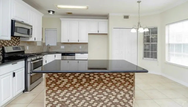 a kitchen with a sink refrigerator and cabinets