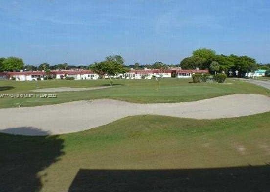 218 Brittany F, Unit E Delray Beach, FL 33446 - Photo 14 of 21 a view of a golf course with a lake
