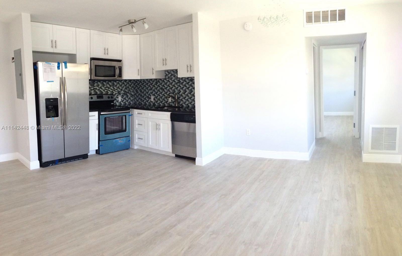 218 Brittany F, Unit E Delray Beach, FL 33446 - Photo 3 of 21 a kitchen with stainless steel appliances granite countertop a refrigerator and a stove