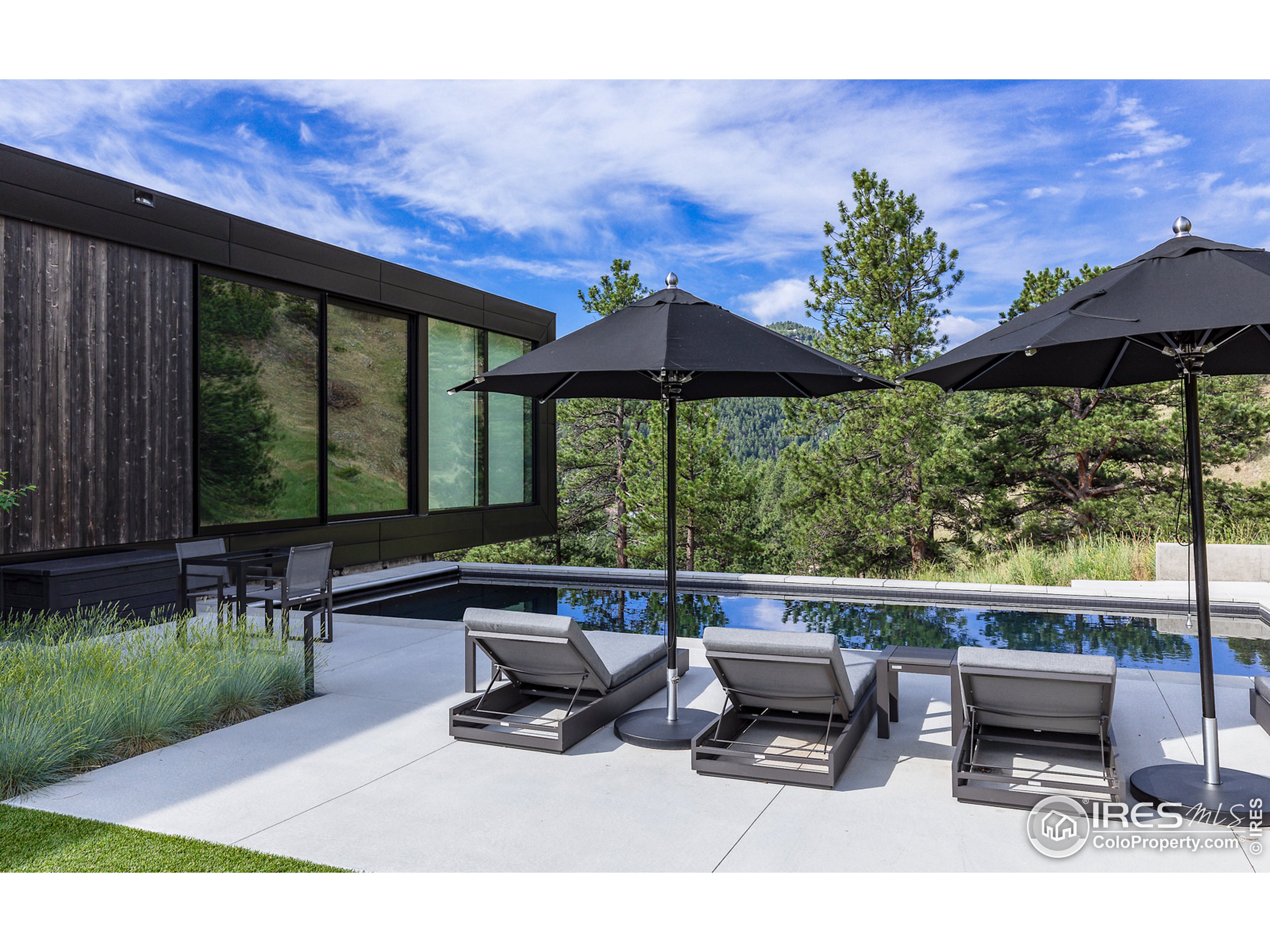 Undisclosed Address Boulder, CO 80302 - Photo 6 of 40 a roof deck with table and chairs under an umbrella with a fire pit