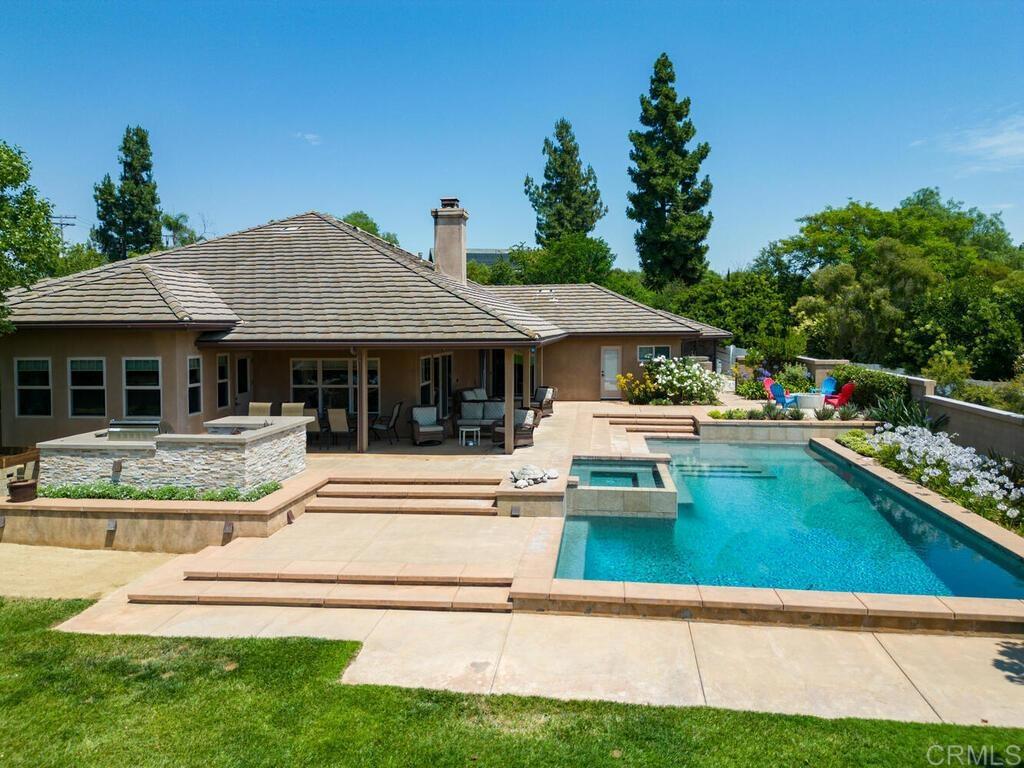 a view of swimming pool with lawn chairs and plants