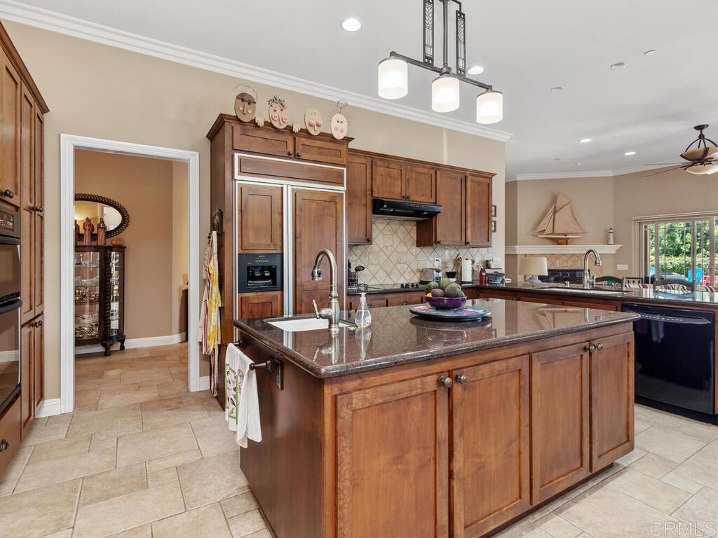 1845 Acacia Lane Fallbrook, CA 92028 - Photo 9 of 54 a kitchen with kitchen island granite countertop a sink counter top space appliances and cabinets