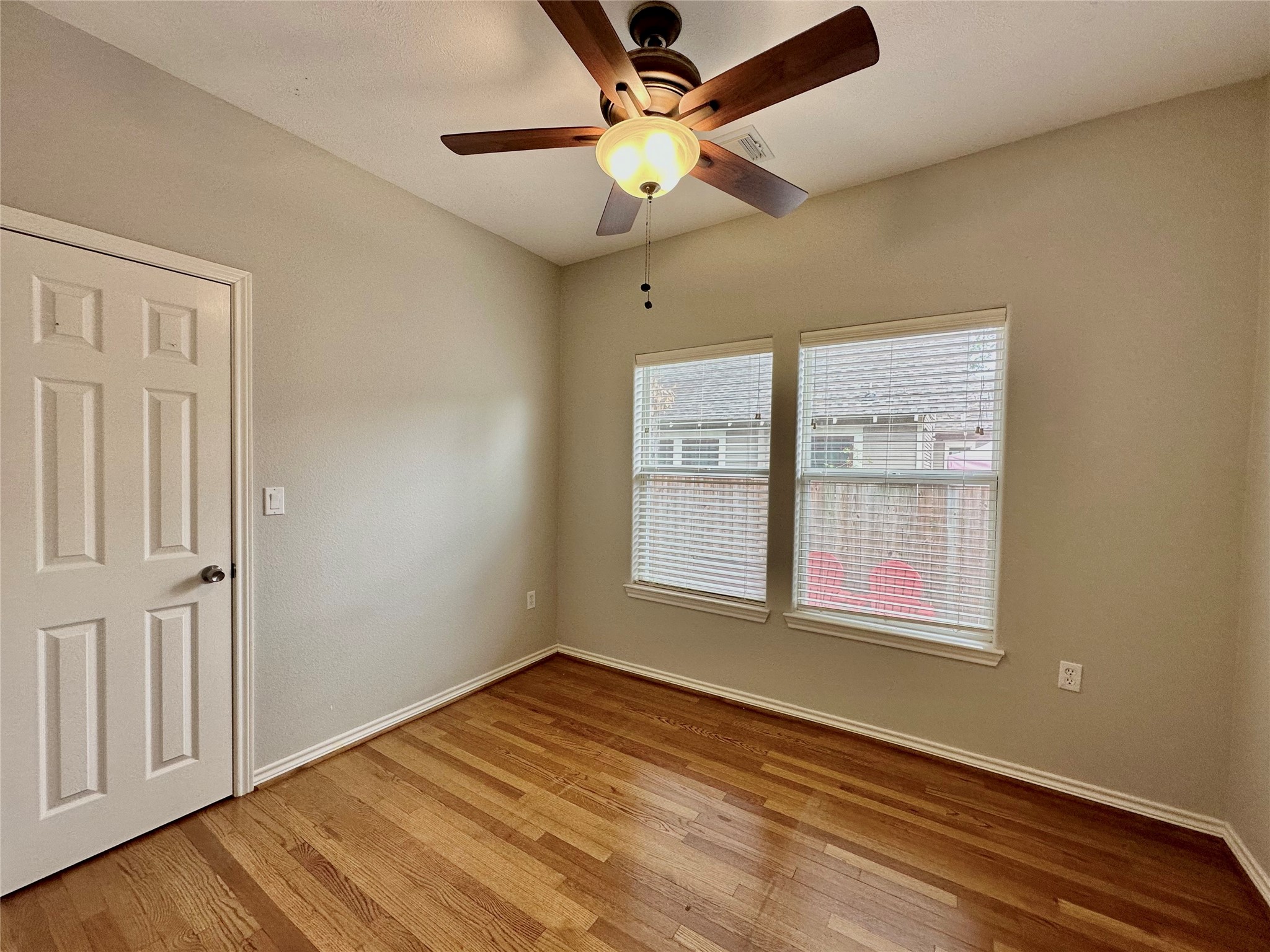 112 Munford Street Houston, TX 77008 - Photo 18 of 28 an empty room with wooden floor chandelier fan and windows