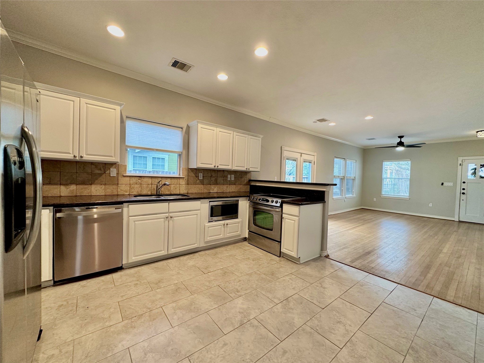 112 Munford Street Houston, TX 77008 - Photo 20 of 28 a kitchen with stainless steel appliances granite countertop a stove top oven a sink a refrigerator and white cabinets