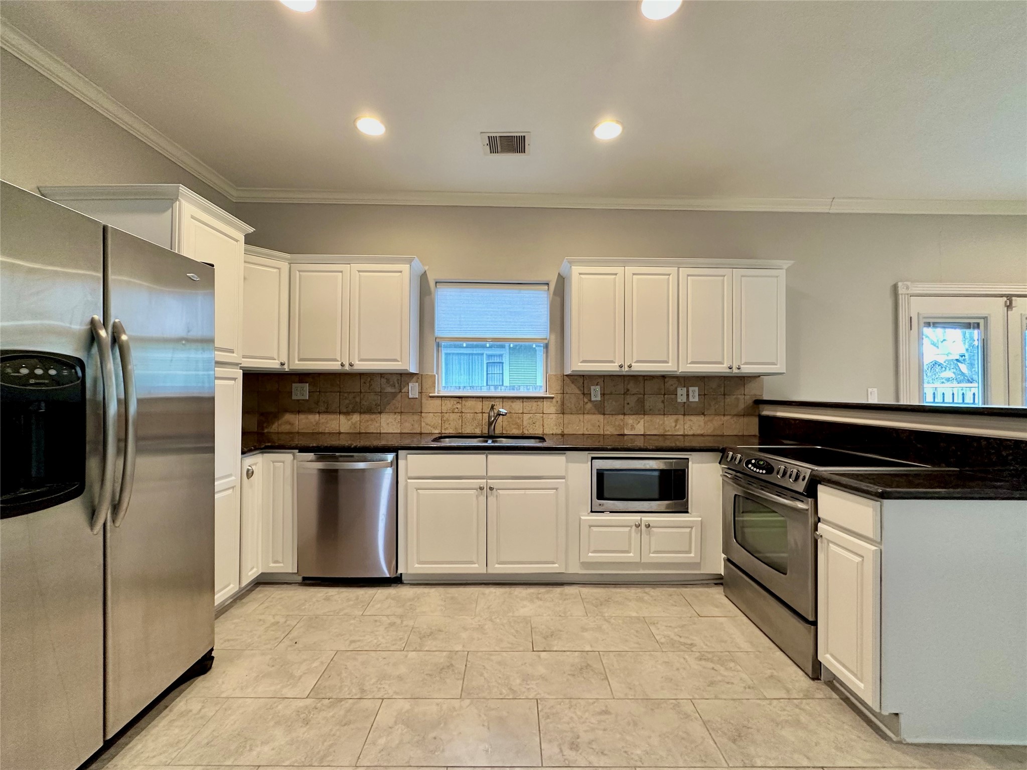 112 Munford Street Houston, TX 77008 - Photo 6 of 28 a kitchen with stainless steel appliances granite countertop a stove a sink and a refrigerator