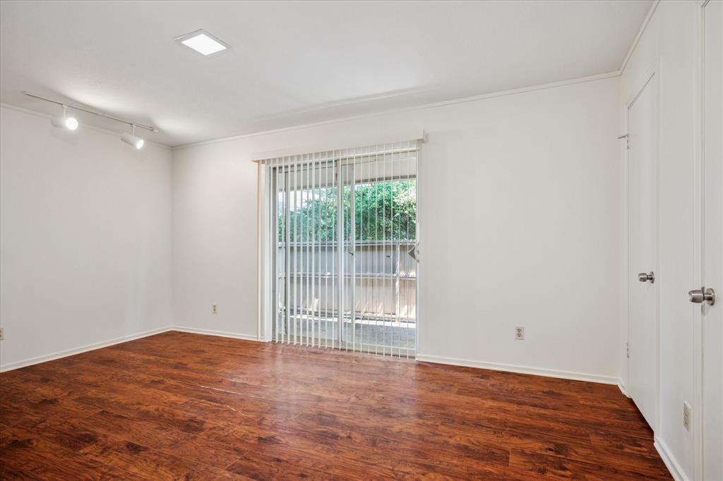 11400 Park Central Place, Unit C Dallas, TX 75230 - Photo 11 of 20 a view of an empty room with wooden floor and a window