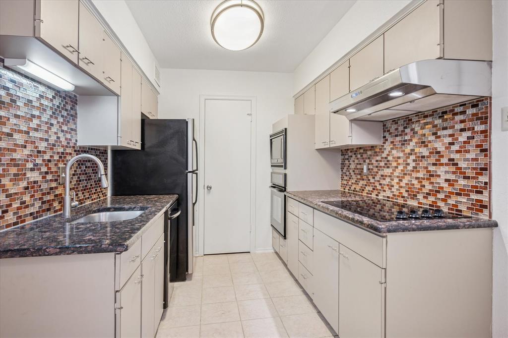 11400 Park Central Place, Unit C Dallas, TX 75230 - Photo 6 of 20 a kitchen with stainless steel appliances granite countertop a sink stove and refrigerator