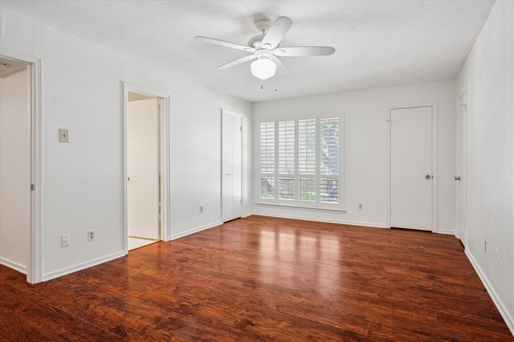 11400 Park Central Place, Unit C Dallas, TX 75230 - Photo 9 of 20 a view of an empty room with wooden floor and a ceiling fan