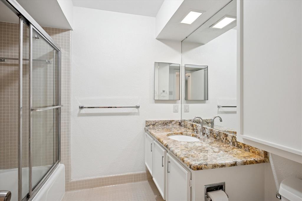 11400 Park Central Place, Unit C Dallas, TX 75230 - Photo 10 of 20 a bathroom with a granite countertop sink and a mirror