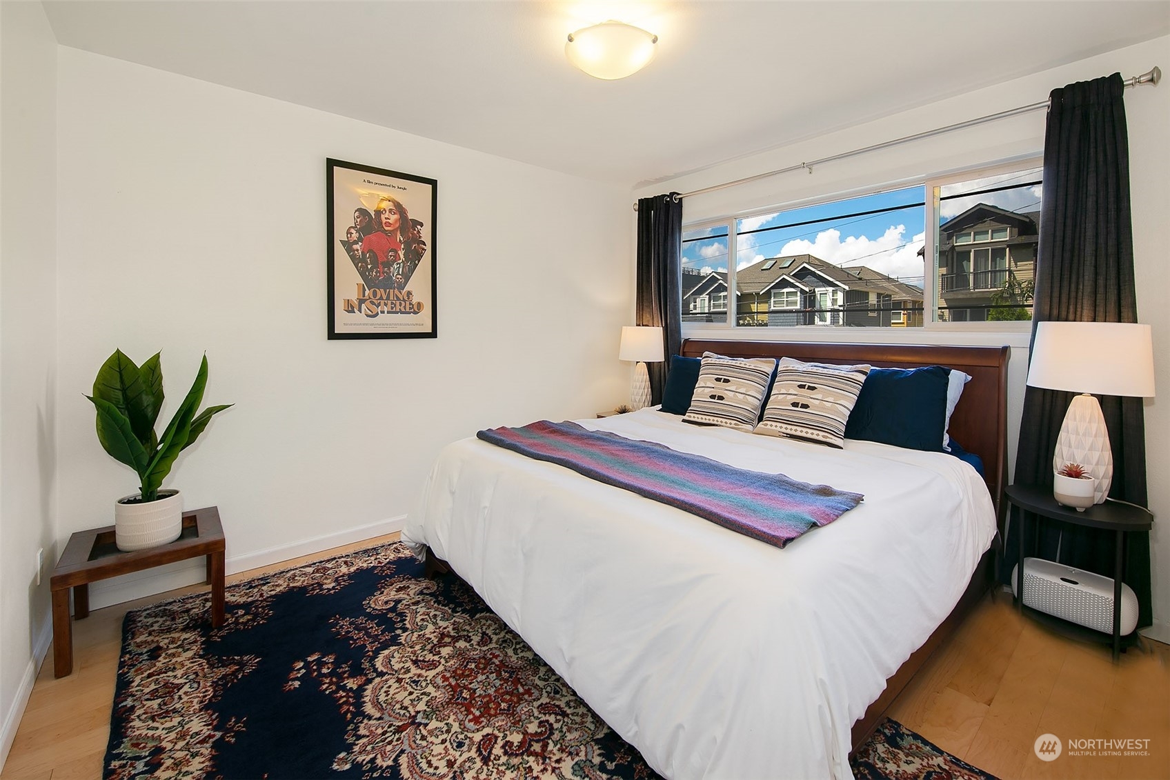 3636 Evanston Avenue North, Unit 4 Seattle, WA 98103 - Photo 7 of 19 a bedroom with a bed and wooden floor