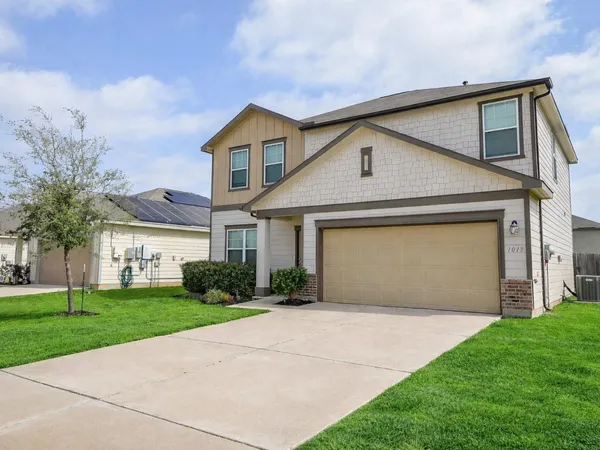 a front view of a house with a yard and garage
