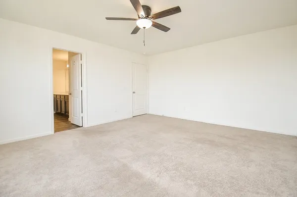 an empty room with a ceiling fan and a window