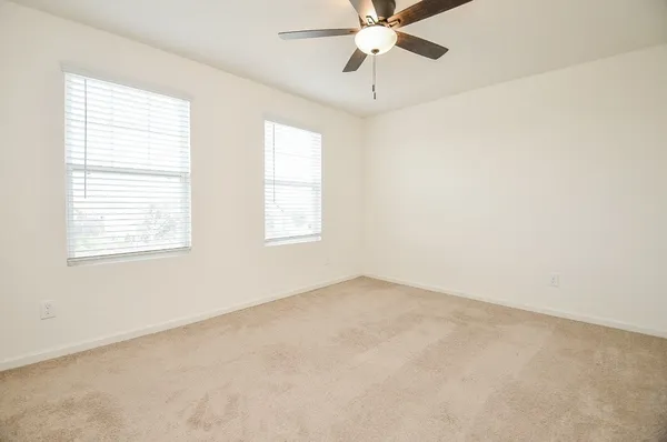 an empty room with a window and a fan