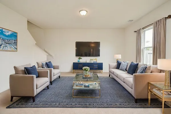 a living room with furniture a flat screen tv and a large window