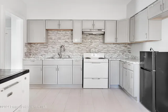 a kitchen with stainless steel appliances granite countertop a refrigerator sink and cabinets