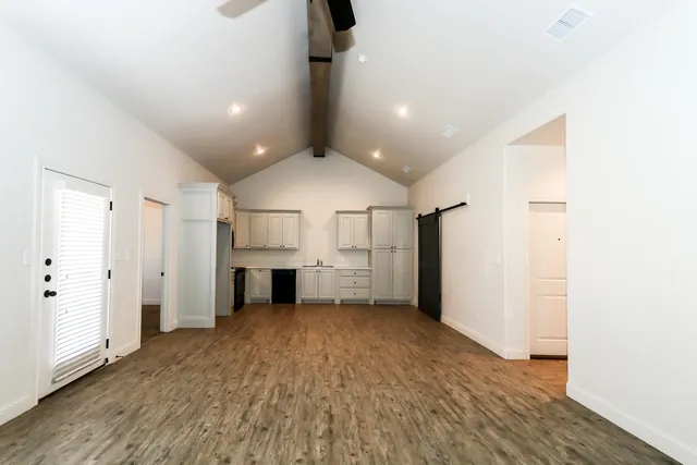 an empty room with wooden floor and a ceiling fan