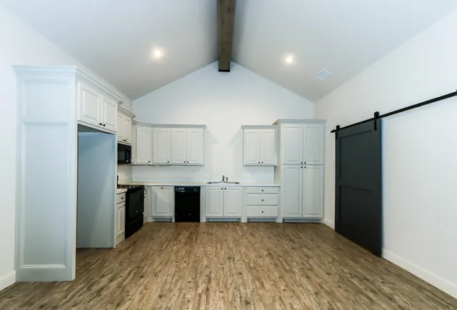 a large kitchen with a refrigerator and a stove top oven
