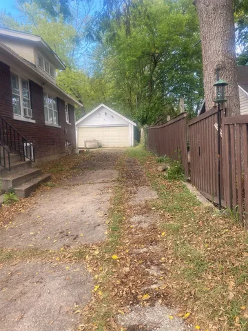 a view of a yard with wooden fence