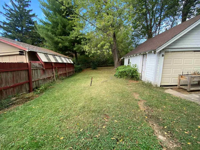 a backyard of a house with barbeque oven table and chairs