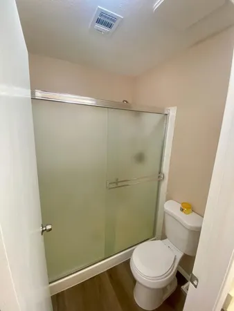 a white toilet sitting next to a shower