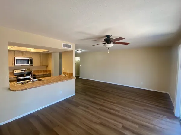 a view of a kitchen with wooden floor and a ceiling fan