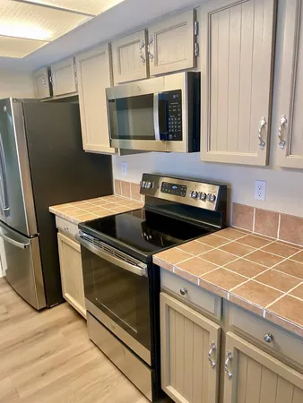 a kitchen with stainless steel appliances granite countertop a stove microwave and refrigerator