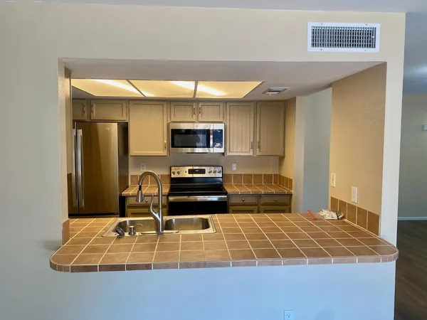a kitchen with kitchen island a stove a sink and a microwave