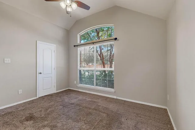 an empty room with a window and a fan