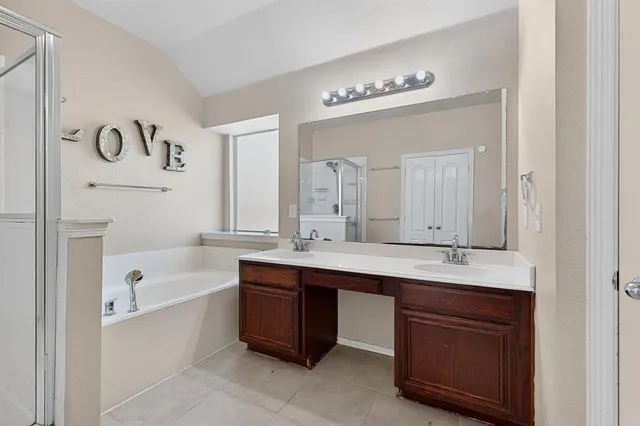 a bathroom with a tub a sink and mirror