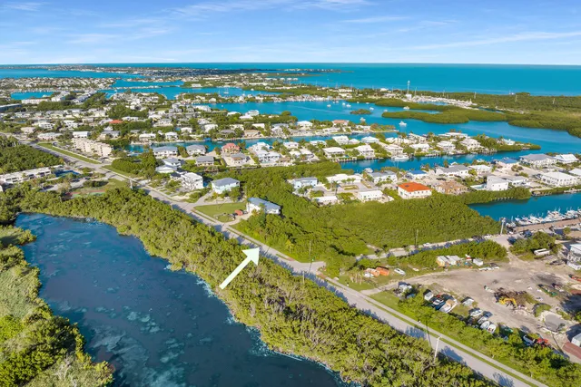 an aerial view of ocean and residential houses with outdoor space