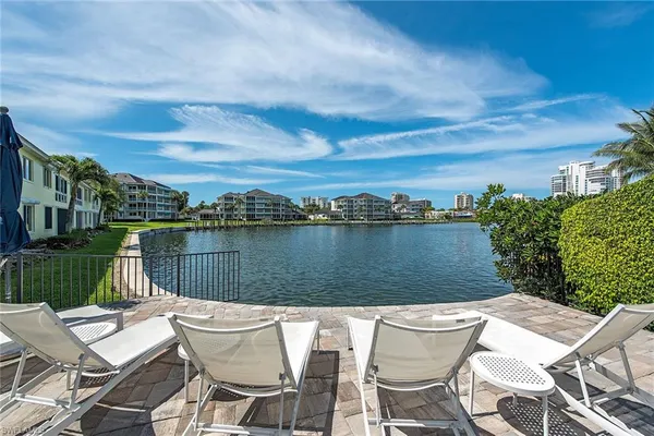 a view of a lake with couches chairs and city view