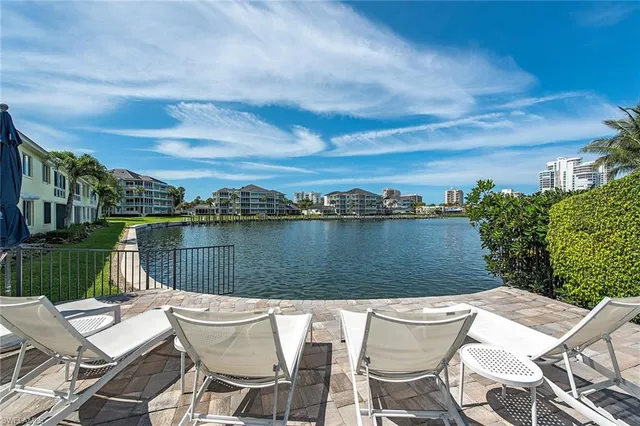 a view of a lake with couches chairs and city view