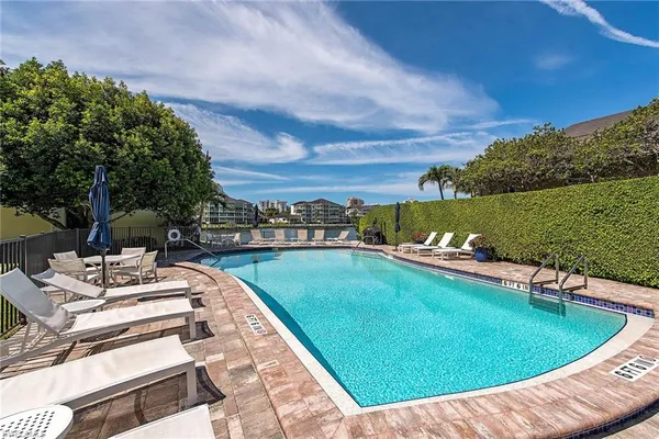 a view of a swimming pool and lounge chairs on th terrace