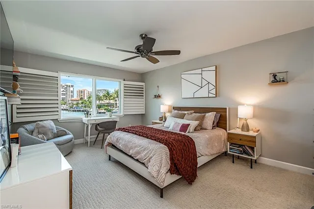 a spacious bedroom with a bed a couch and a large window