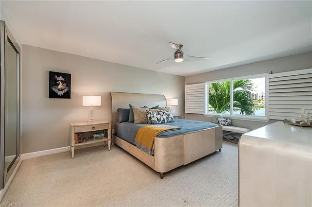 a bedroom with a bed and a large window