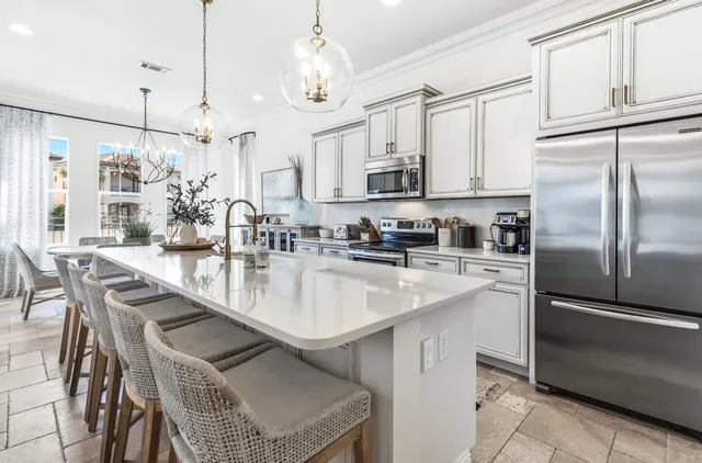 a kitchen with stainless steel appliances granite countertop a kitchen island a table and chairs