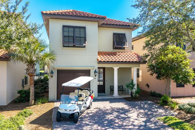 a front view of a house with glass windows and palm tree