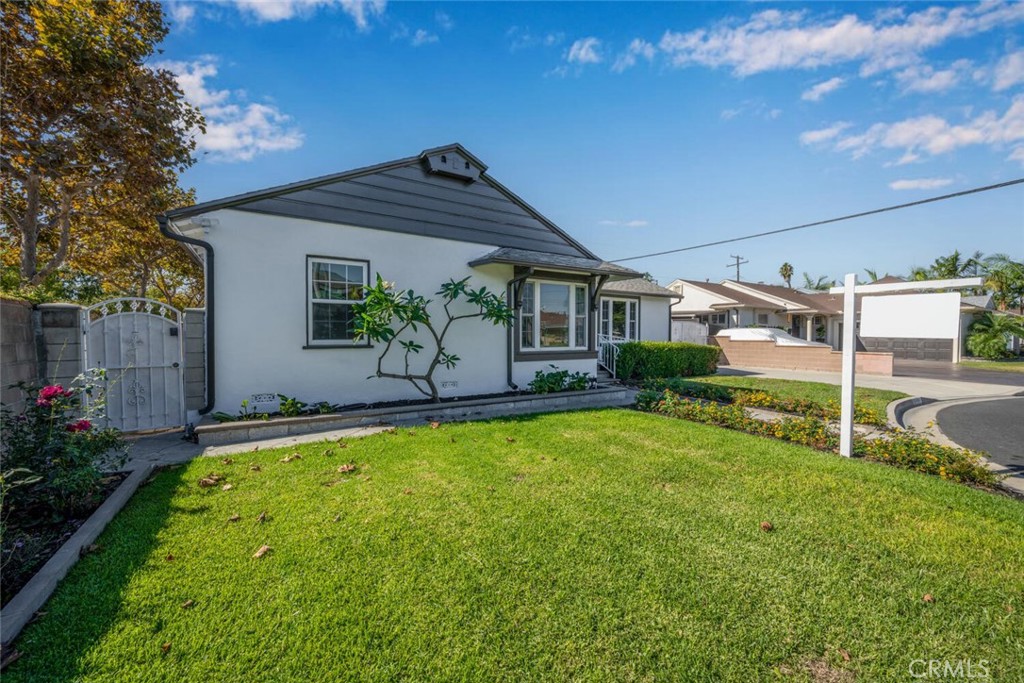 7964 Comolette Street Downey, CA 90242 - Photo 20 of 22 a front view of a house with garden